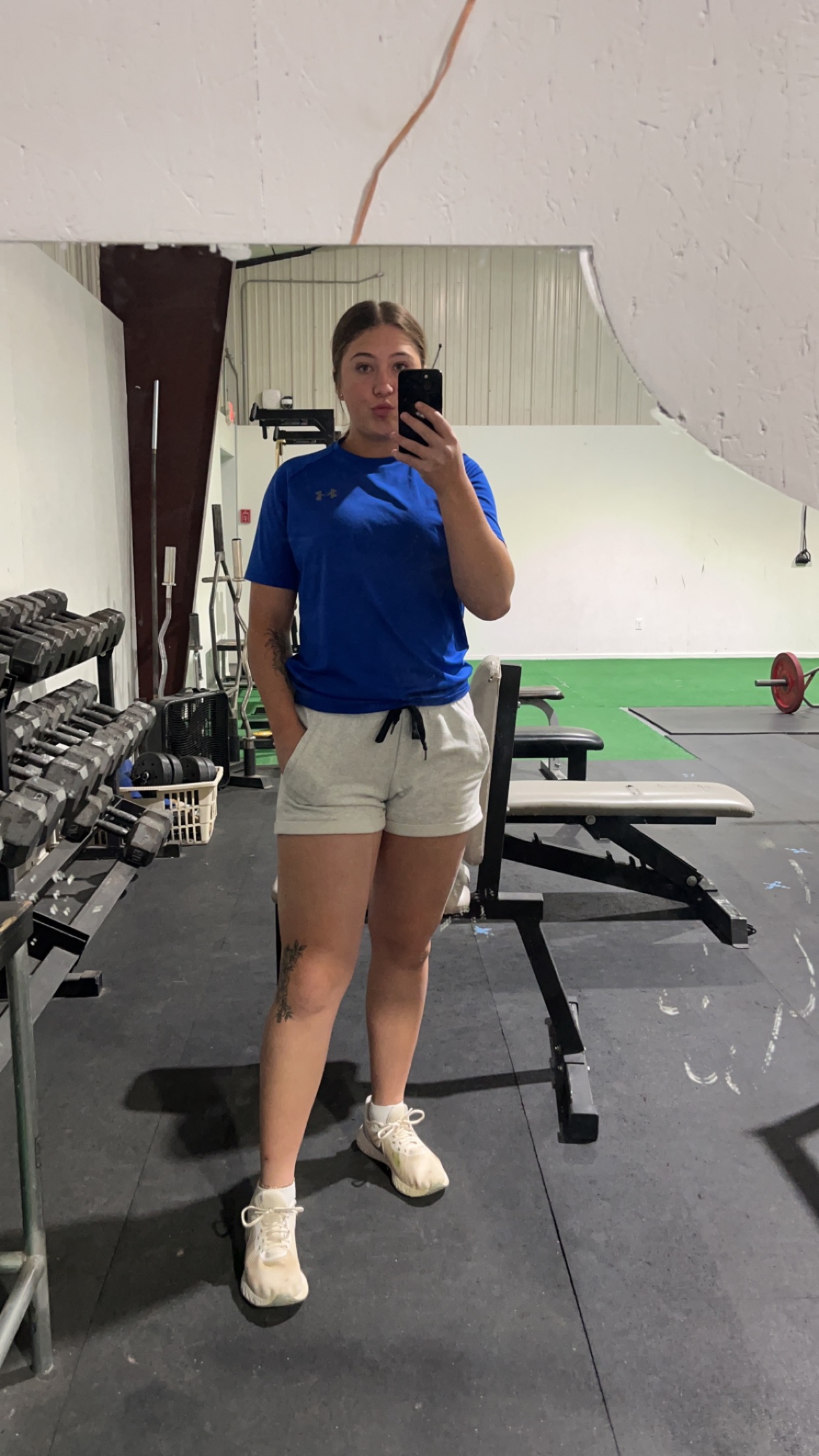 Rylee taking a mirror selfie in the gym between sets