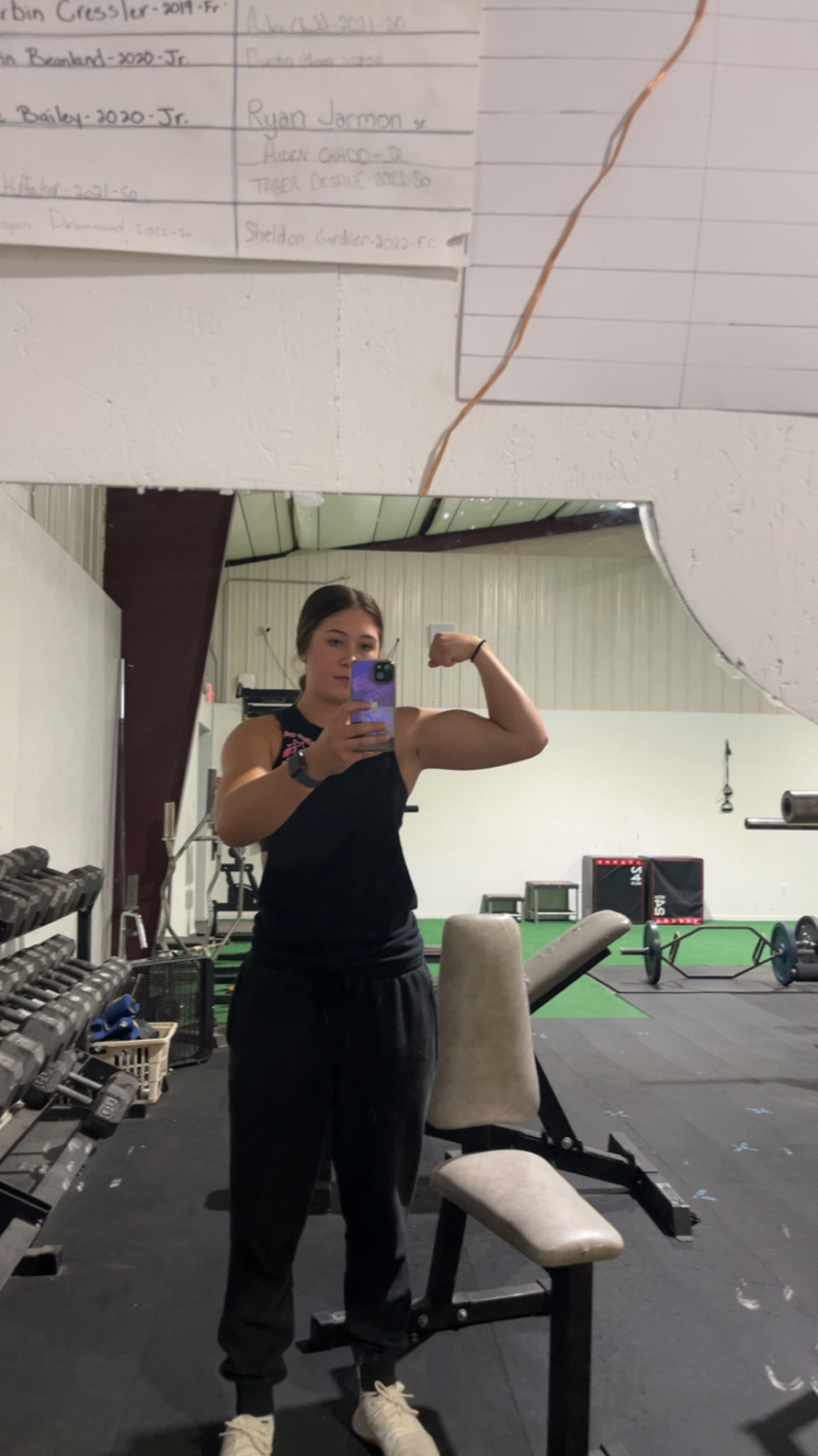 Rylee flexing in a gym mirror after training